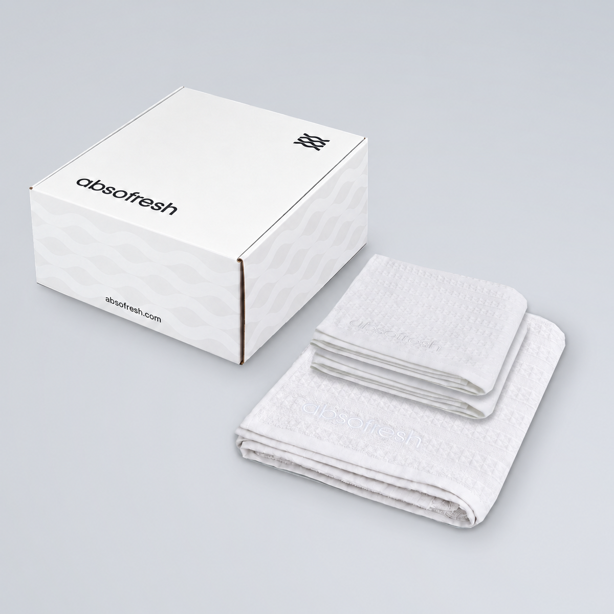 AeroWeave Home Essentials Gift Set with one Pure White bath towel and two hand towels beside the Absofresh gift box